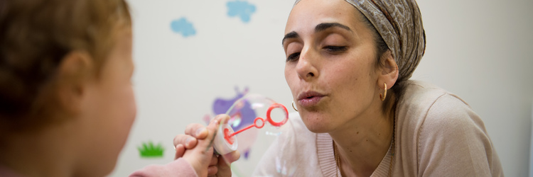 NARCI staff member entertains a patient with soap bubbles